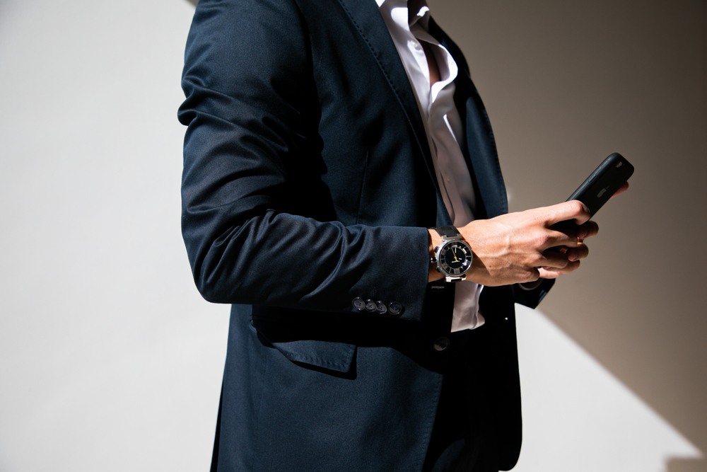 homem de terno com um rolex no braço