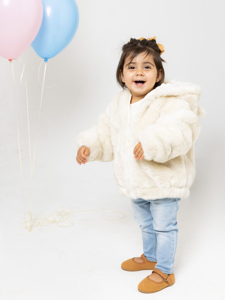 menina com casaco branco e calça jeans, ambos de grife