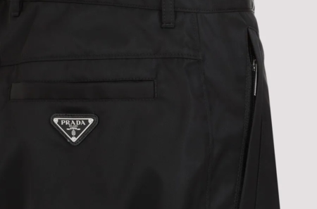 Uma calça Prada com destaque para a logo da marca no bolso da calça.