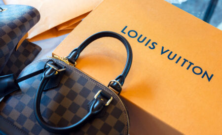 Bolsa de luxo Louis Vuitton sobre caixa da marca, representando conceito de moda circular e consumo consciente no mercado de acessórios premium.