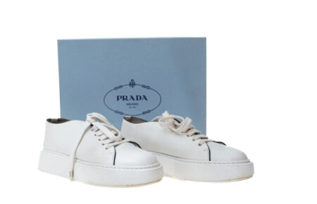 Tênis branco de couro Prada com solado alto e acabamento sofisticado, perfeito para composições refinadas e estilo casual elegante feminino.