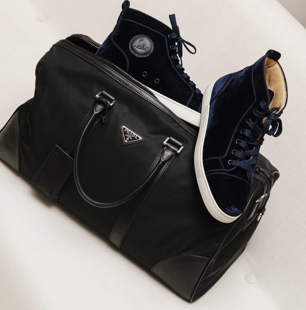 Bolsa Prada preta com tênis azul de veludo, combinação sofisticada e moderna, ideal como presente para Dia dos Pais de luxo.